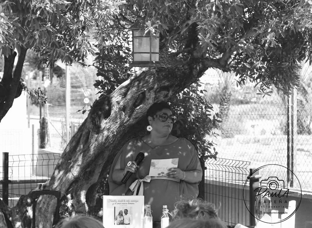 Elena, en blanco y negro, conduciendo una ceremonia al aire libre